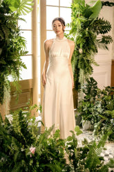 Elegant halter neck silk dress with open back and floor-length fluid silhouette